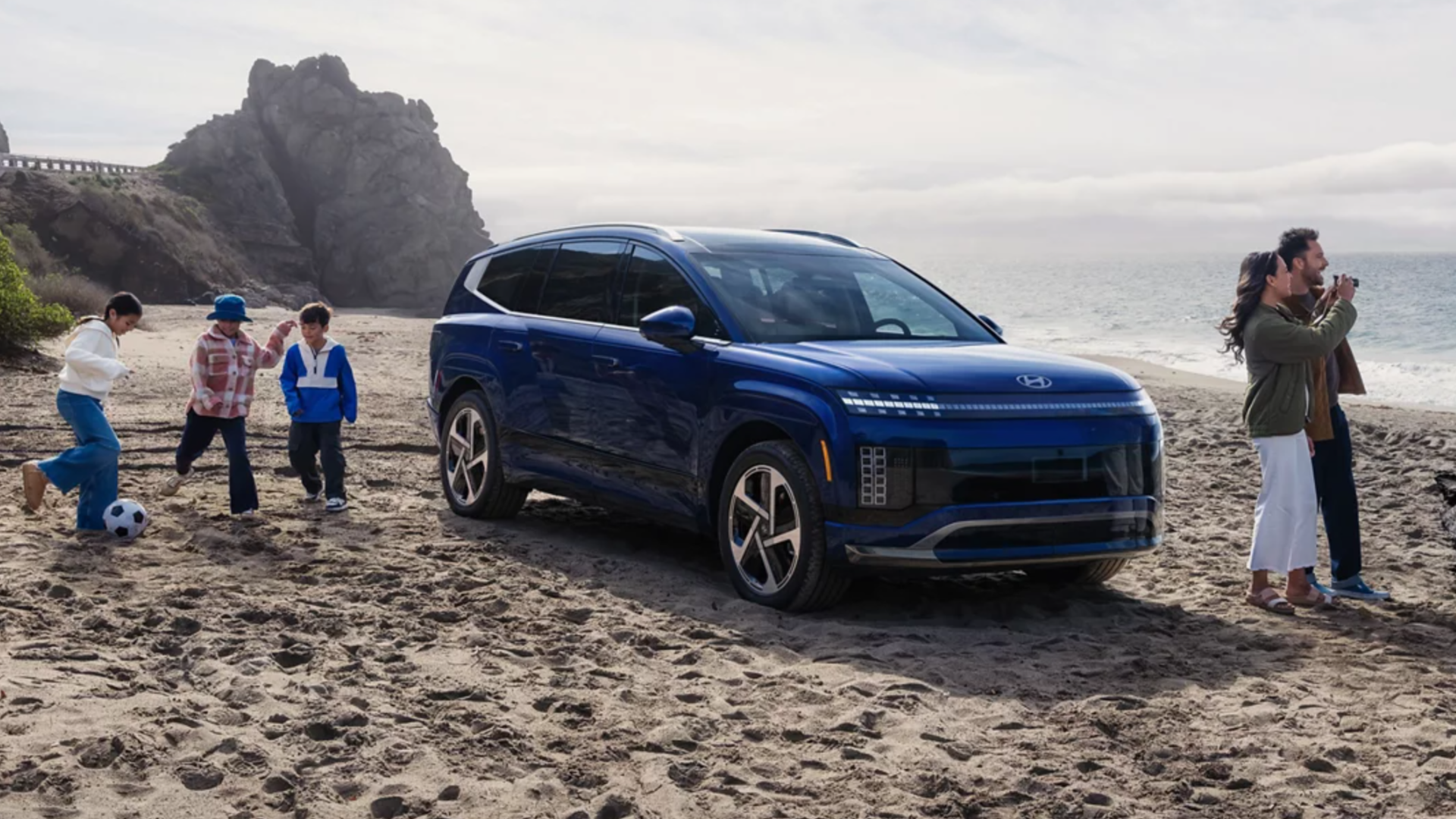 IONIQ 9 sur la plage, accompagnant une famille active